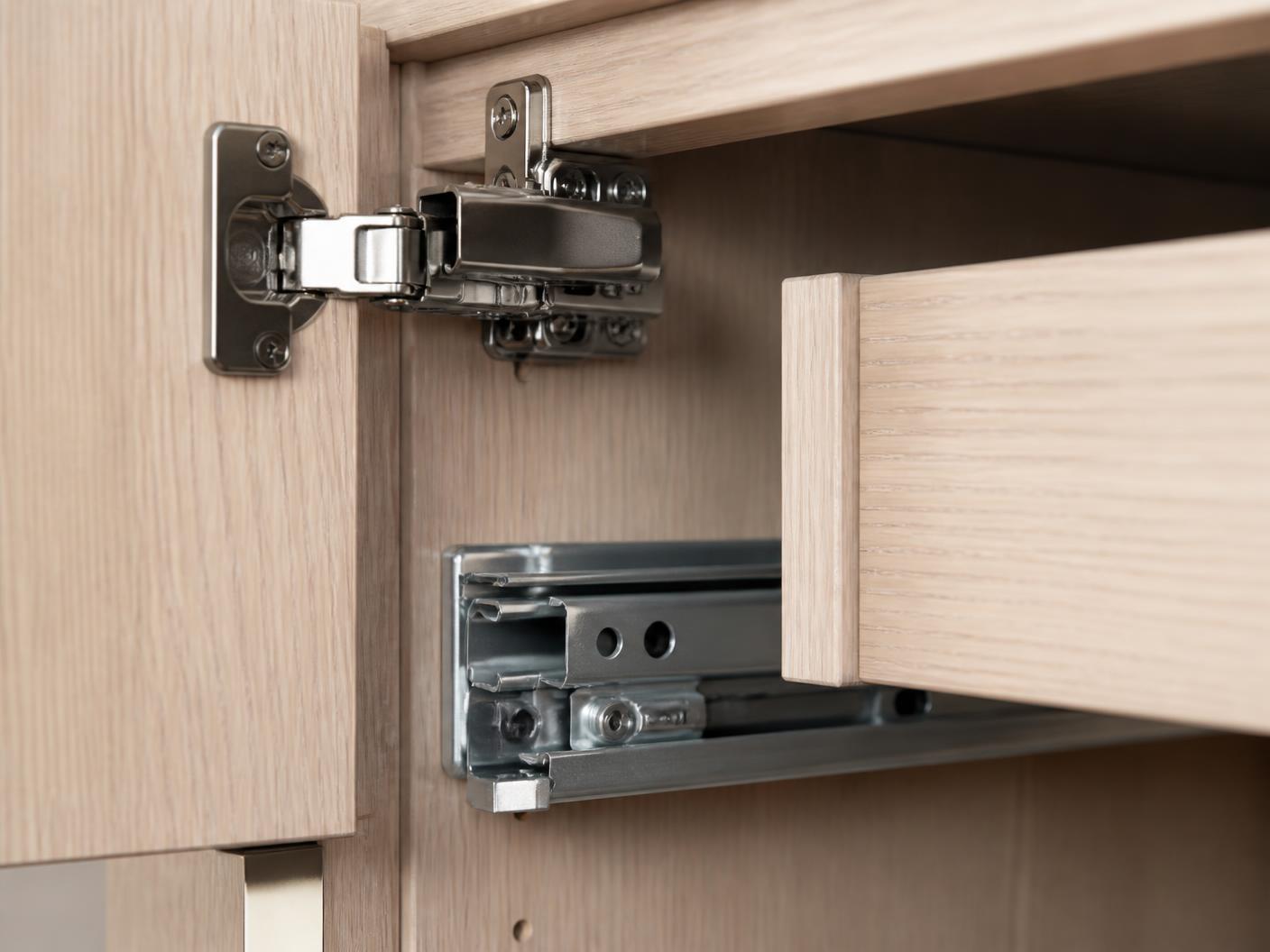 Concealed soft-close hinge and undermount drawer runner inside an oak cabinet